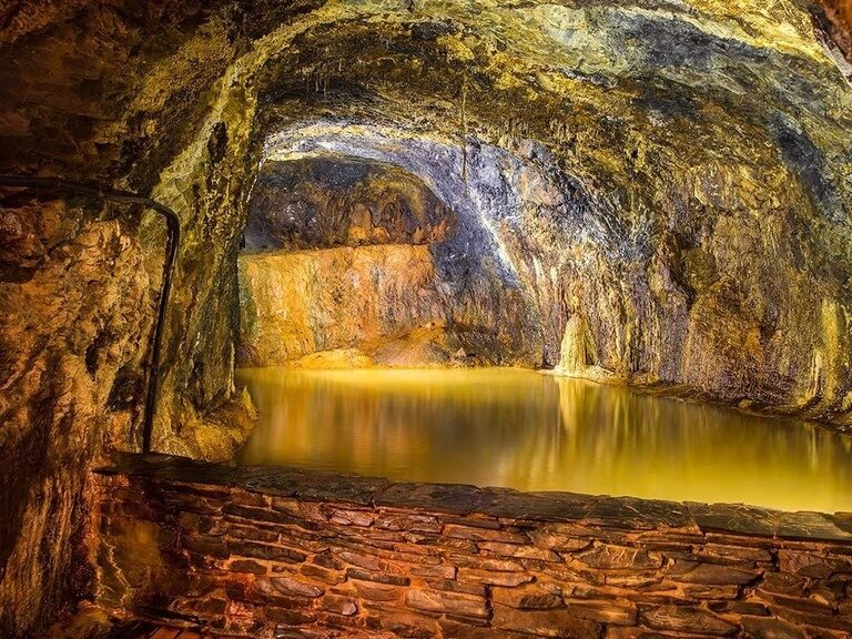 Warm beleuchtete unterirdische Wasserstelle in den Grotten, empfohlen vom Hotel Oberhof.